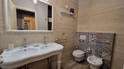 a bathroom with a sink and a toilet and a mirror at La Perla del Borgo B&B in Pisa