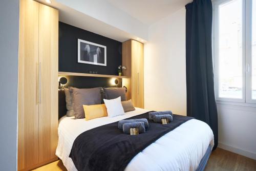 um quarto com uma cama grande com duas almofadas em HeavnStay Suite 2 Cannes Centre em Cannes