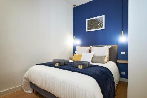 um quarto com uma cama grande e uma parede azul em HeavnStay Suite 2 Cannes Centre em Cannes