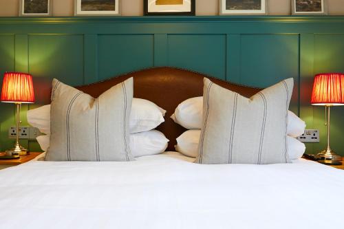 a bedroom with a bed with white pillows and two lamps at The Grainary Boutique B&B in Scarborough