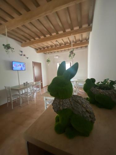 two green stuffed animals sitting on a table in a room at B&B I Giardini in Pieve Torina