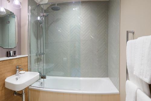 a bathroom with a shower and a sink at The Grainary Boutique B&B in Scarborough