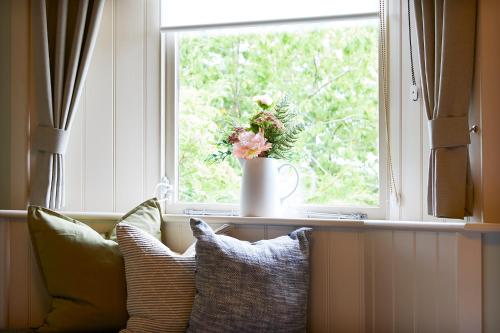 a window with a vase with flowers on a window sill at The Grainary Boutique B&B in Scarborough
