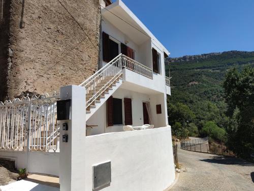 a white house with a balcony with a view at Sa Dommu 'e su coro in Triei