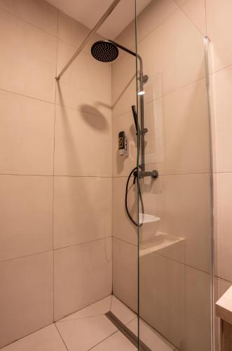 a shower with a glass door in a bathroom at "Echo" B&B rooms, boutique beach hotel in Rabac
