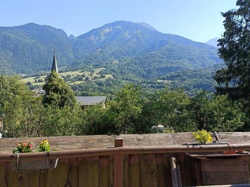 a fence with flowers on it with mountains in the background at Appartement avec terrasse et parking Privé in Aigueblanche