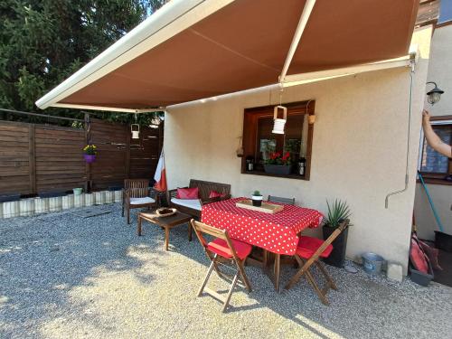 un patio con mesa y sillas bajo una sombrilla en Appartement avec terrasse et parking Privé, en Aigueblanche