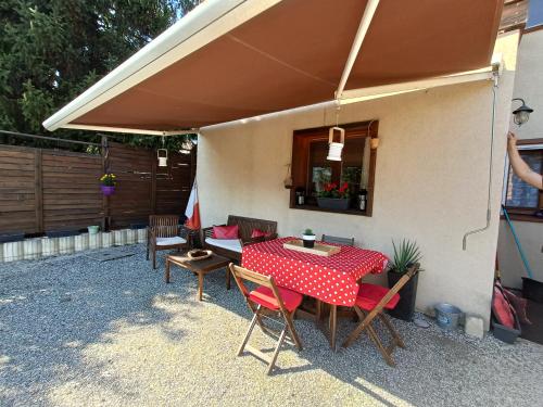 a patio with a table and chairs under an umbrella at Appartement avec terrasse et parking Privé in Aigueblanche