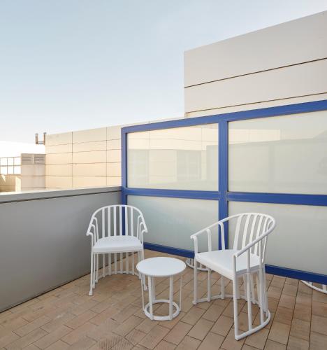two white chairs and a table on a roof at Iraipe Logroño Hotel in Logroño