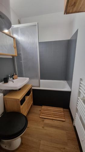 une salle de bain avec un lavabo, des toilettes et une baignoire dans l'établissement Appartement de station rénovée avec parking, à Habère-Poche