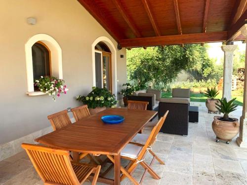 ein Holztisch und Stühle auf einer Terrasse in der Unterkunft Corte dei Mirti, Appartamento indipendente con ampia veranda in Iglesias