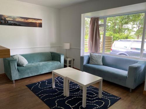 a living room with two blue couches and a table at The Bunkhouse in Applecross