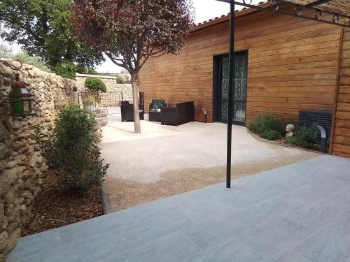 a patio of a house with a stone wall at Gite d'Emma in Camaret-sur-Aigues
