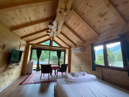 a bedroom in a log cabin with a bed and chairs at Esinti Bungalows Otel in Çamlıhemşin