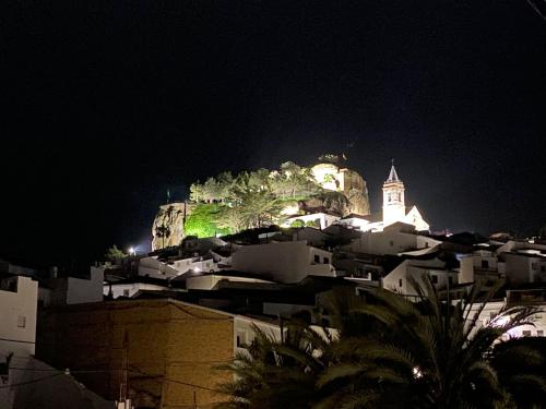 a city at night with a castle in the background at Hostel Rural Gaitanes, Caminito del Rey, Ardales in Ardales