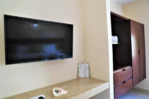 a living room with a large flat screen tv on a wall at Hotel 12 BEES by Kavia in Playa del Carmen
