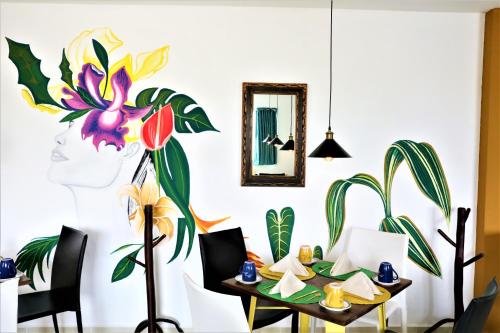 a dining room with a table with a flower mural on the wall at Hotel 12 BEES by Kavia in Playa del Carmen