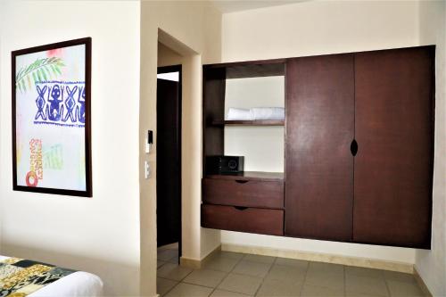 a bedroom with a wooden cabinet in a room at Hotel 12 BEES by Kavia in Playa del Carmen
