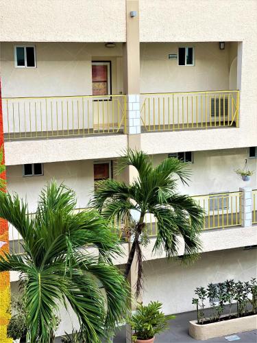 a building with palm trees in front of it at Hotel 12 BEES by Kavia in Playa del Carmen