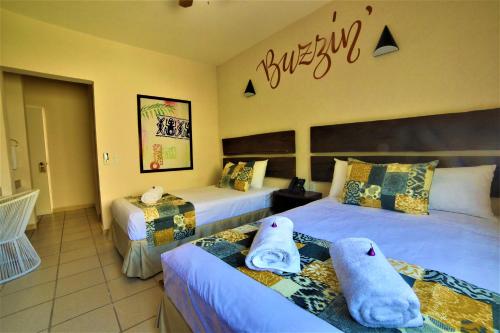 a bedroom with two beds with towels on them at Hotel 12 BEES by Kavia in Playa del Carmen