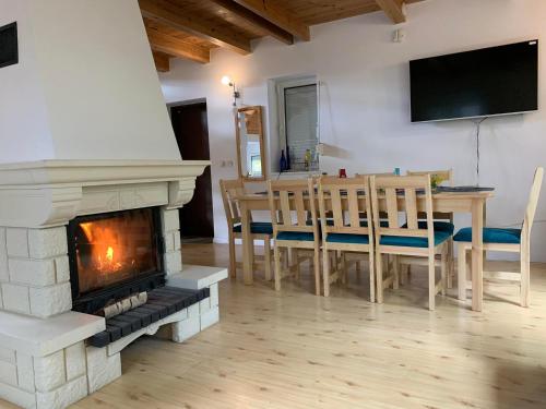 a living room with a fireplace and a table and chairs at Domek Między Jeziorami in Wąglikowice