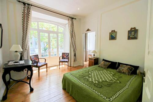 a bedroom with a green bed and a table and chairs at Donapart in Lisbon