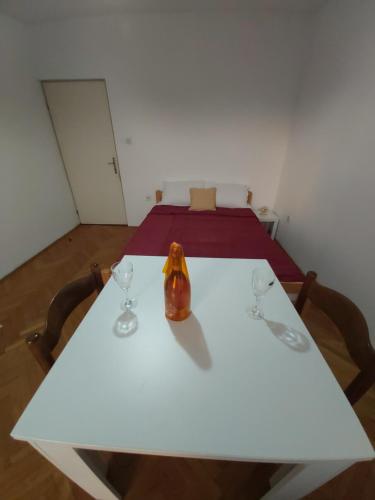 a white table with two glasses and a vase on it at Apartments Maki 2 i 3 in Tivat