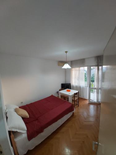 a bedroom with a bed and a table in it at Apartments Maki 2 i 3 in Tivat