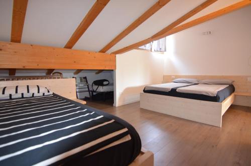 um quarto com uma cama num quarto com tectos em madeira em Holiday home Danima em Pietramurata