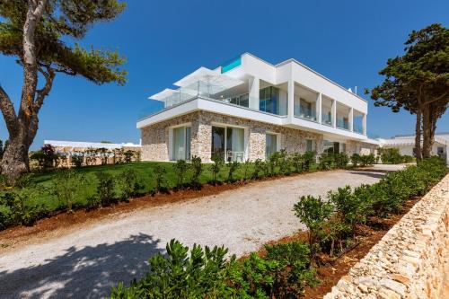 ein großes weißes Haus auf einem Hügel mit Bäumen in der Unterkunft Perla Saracena Hotel & Restaurant in Salve