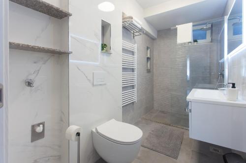 ein weißes Badezimmer mit Toilette und Waschbecken in der Unterkunft Villa Maestral in Vinišće