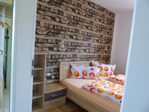 OberweidにあるFerienwohnung Csilla 2のレンガの壁とベッドが備わるベッドルーム1室が備わります。