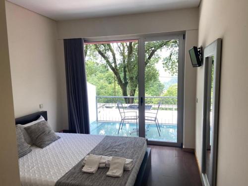 a bedroom with a bed with two towels on it at Fonte dos Amores - Alojamento in Caniçada