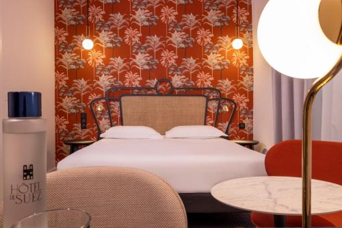 En eller flere senger på et rom på Hotel De Suez