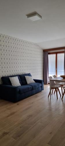 a living room with a blue couch and a table at Casa Barcelli Sport & Family Apartments in Nago-Torbole
