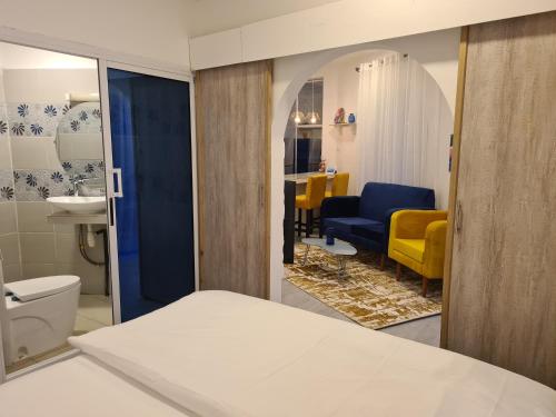 a room with a bed and a bathroom with a sink at Dolce Vita Palacio in Douala