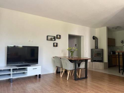 a living room with a dining room table and a television at Ferienwohnung Natur in Balingen