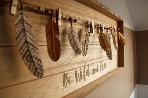 a wooden wall with feathers hanging on it at Quennet in Carrières-sous-Poissy