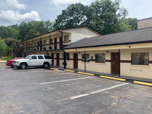 a car parked in a parking lot next to a building at Economy Inn in Tupelo