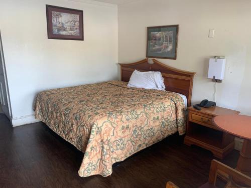 ein Hotelzimmer mit einem Bett und einem Tisch in der Unterkunft Economy Inn in Tupelo