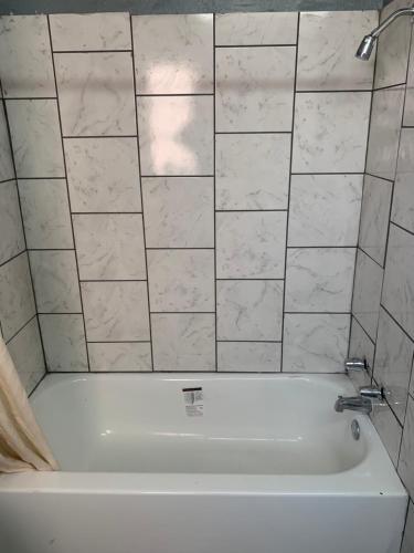 a white bath tub in a bathroom at Economy Inn in Tupelo