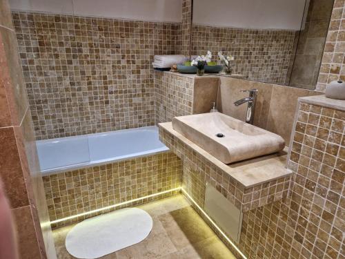 een badkamer met een wastafel en een bad bij Stéph&Marry House Brodina 