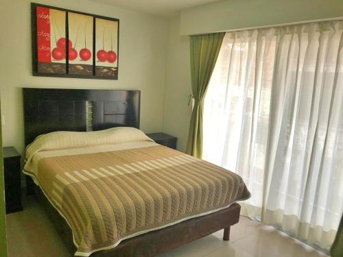 a bedroom with a bed and a large window at Hotel Ruah in Cuernavaca
