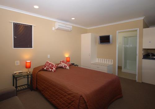 1 dormitorio con 1 cama con 2 almohadas en Discovery Motor Lodge en Masterton