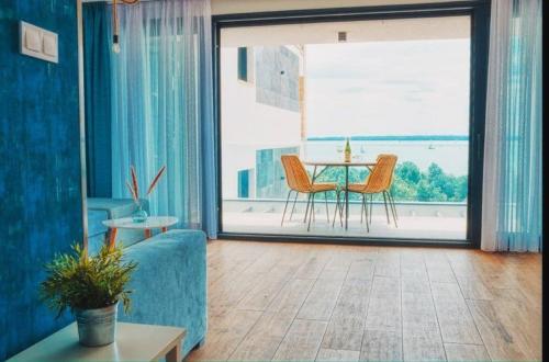 uma sala de estar com um sofá azul e uma mesa em 365Balaton Apartmanok em Alsóörs