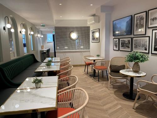 a restaurant with tables and chairs in a room at Hotel De Suez in Paris
