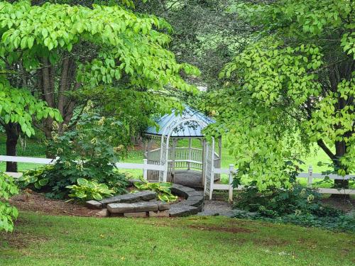 a white gazebo in a garden with trees at McTernan Manor in Franklin
