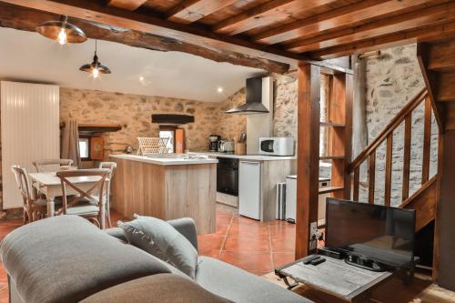 un salon avec un canapé et une télévision dans l'établissement Maison d'hôtes Le Hameau de la Mûre, à Saint-Laurent-du-Pape