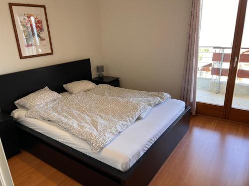 uma cama com um edredão num quarto em Résidence les Crêtes em Torgon
