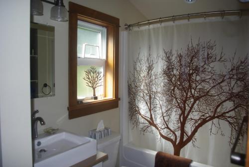 a bathroom with a shower curtain with a tree on it at Wild Coast Chalets in Port Renfrew